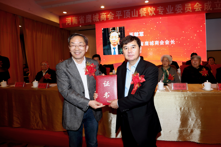 省鹰城商会会长王献军（左一）为餐饮专业委员会当选会长朱志伟（右一）颁发任职证书.jpg