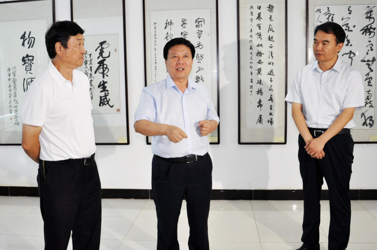 平顶山市委书记周斌（中）和平顶山市人大副主任严寄音（左）、宝丰县委书记张庆一（右）在书画展厅参观.png